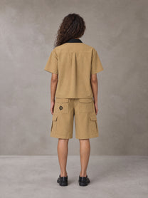 Model wearing SM Eternal Fleur Shirt in Camel Tan with SM Eternal Fleur Utility Shorts in Camel Tan, rear view.