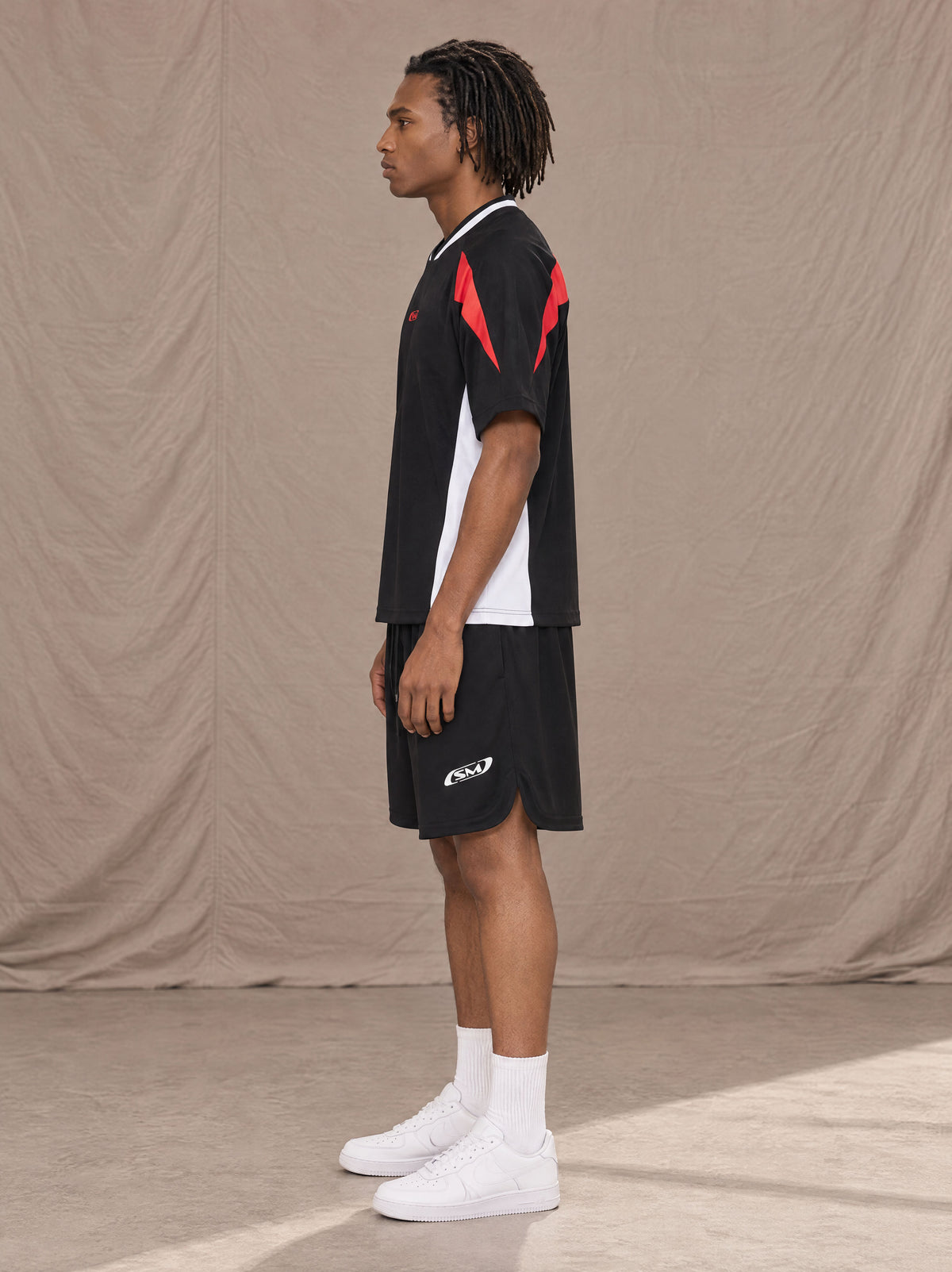 Model wearing SM Motion Vector Jersey in Midnight Black, side view.