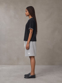 Model wearing SM Plaid Shorts in Floral Grey, side view.