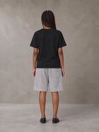 Model wearing SM Plaid Shorts in Floral Grey, rear view.