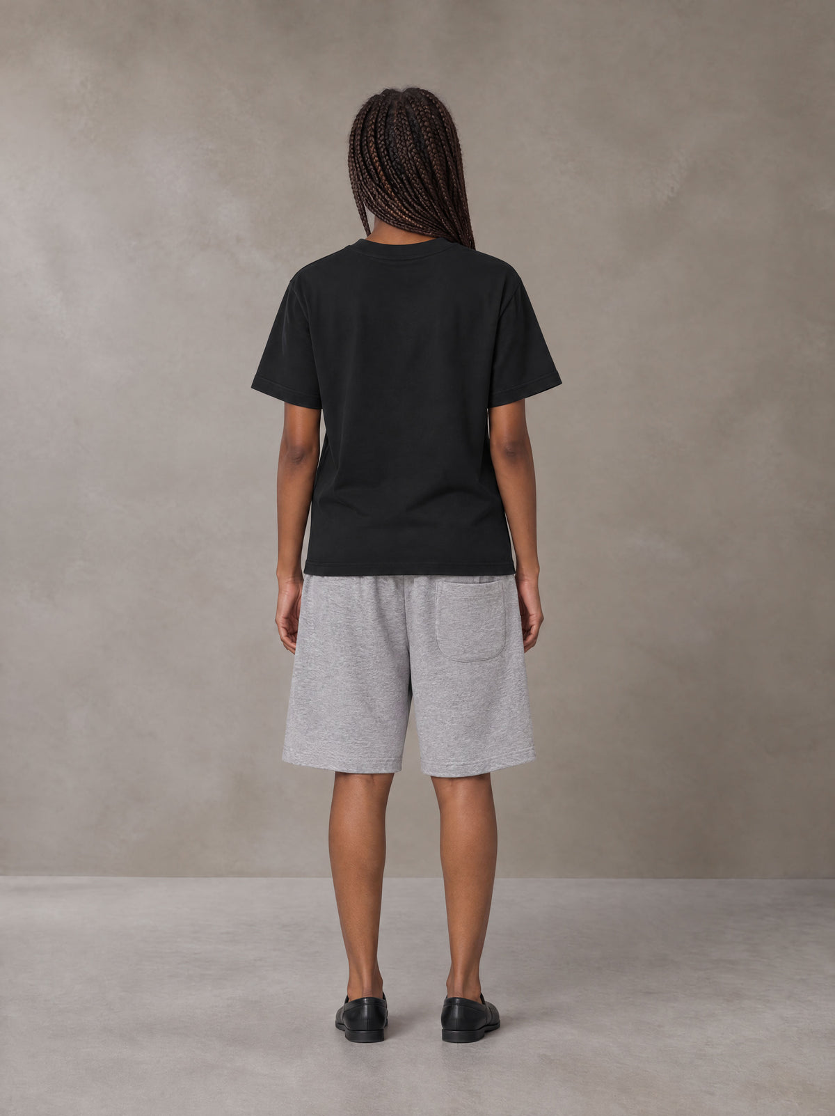 Model wearing SM Plaid Shorts in Floral Grey, rear view.