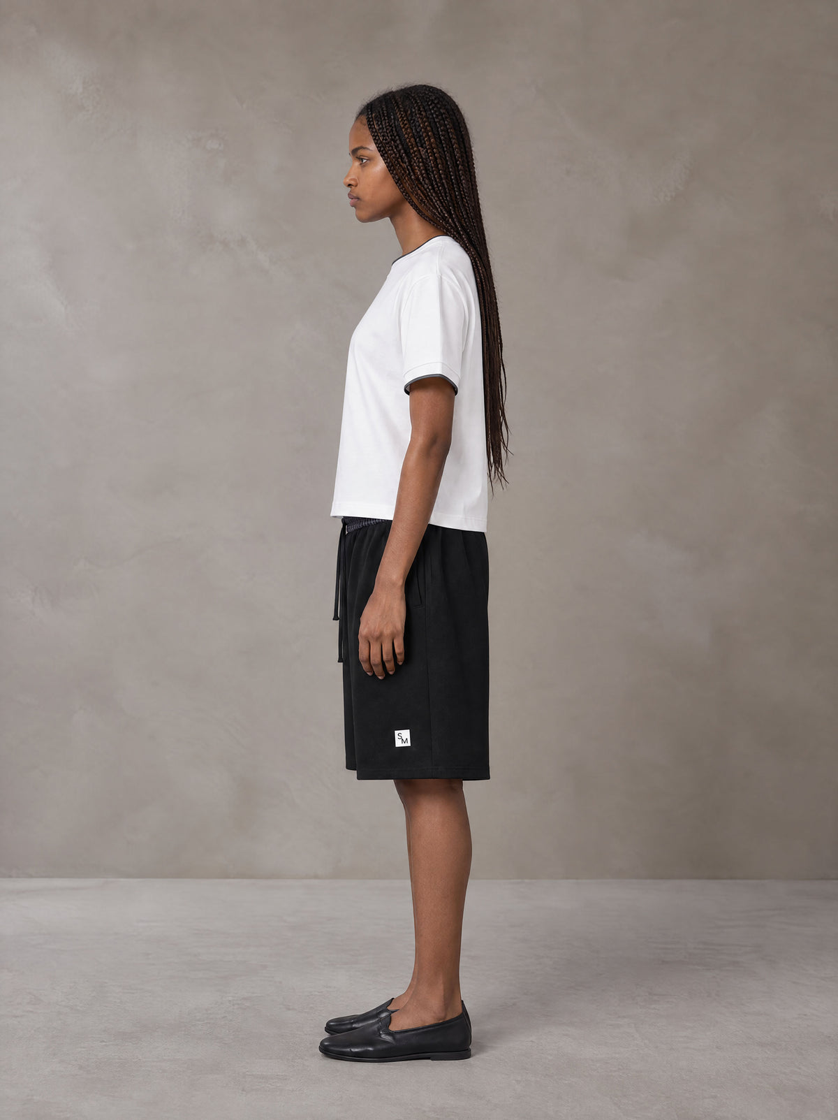 Model wearing SM Plaid Shorts in Midnight Black, side view.