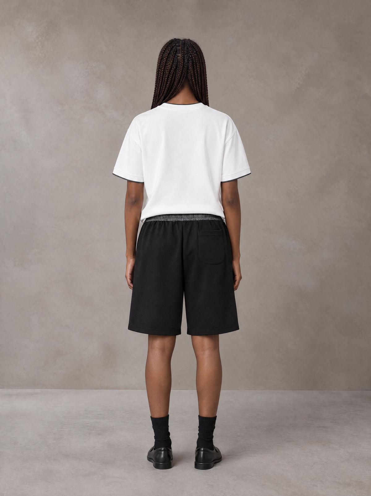 Model wearing SM Plaid Shorts in Midnight Black, rear view.