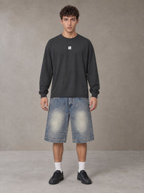 Model wearing SM Sig. Long Sleeve T-shirt in Deep Charcoal, front view.
