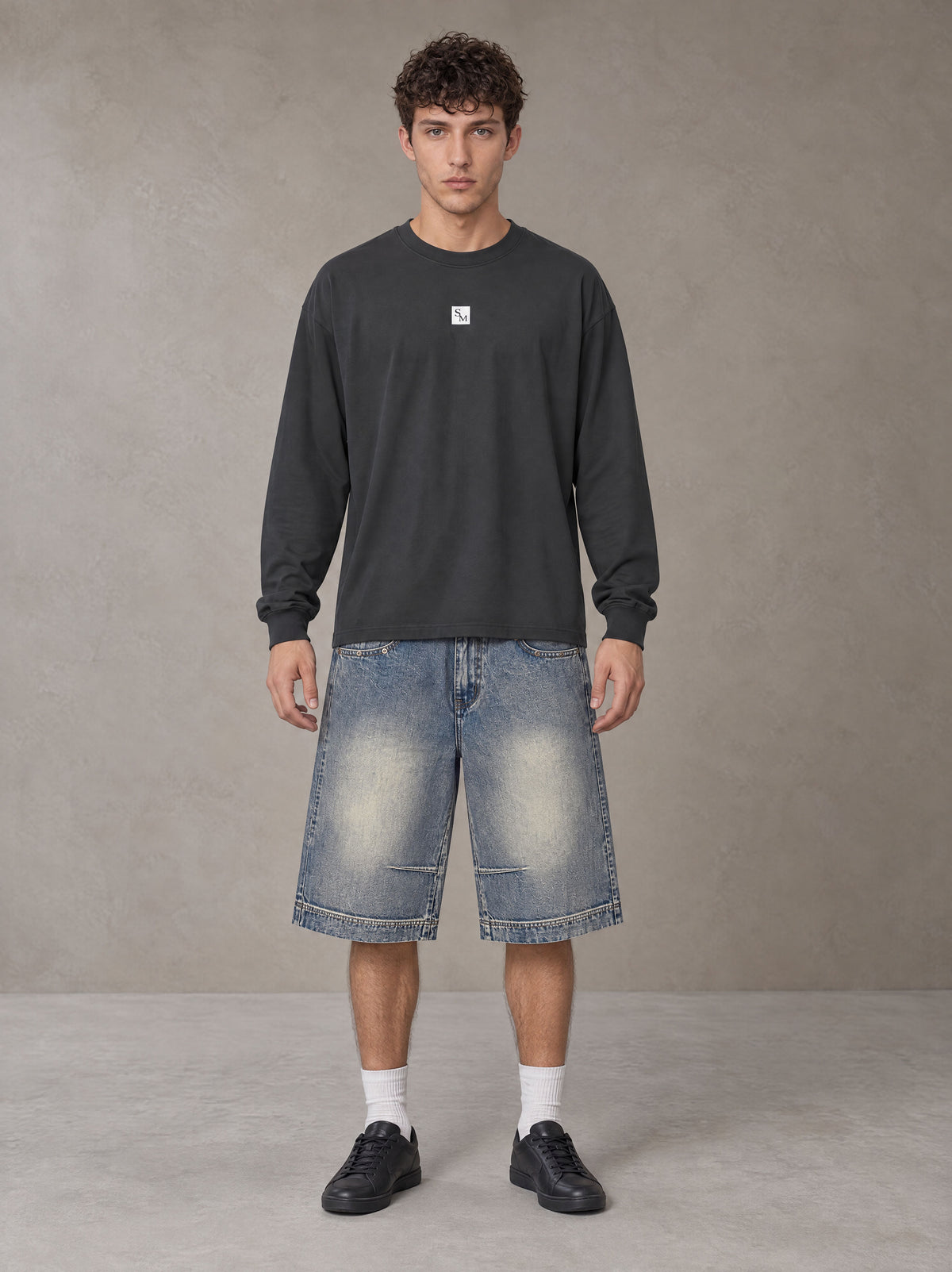 Model wearing SM Sig. Long Sleeve T-shirt in Deep Charcoal, front view.