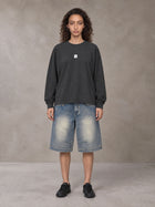 Model wearing SM Sig. Long Sleeve T-shirt in Deep Charcoal, front view.