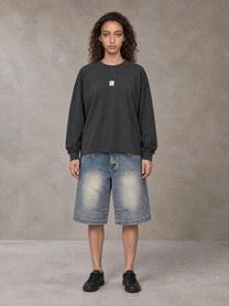 Model wearing SM Sig. Long Sleeve T-shirt in Deep Charcoal, front view.