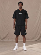 Model wearing SM Motion T-shirt in Midnight Black with SM Motion Oversized Court Shorts in Midnight Black, front view.