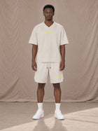 Model wearing SM Motion T-shirt in Oat Grey with SM Motion Oversized Court Shorts in Oat Grey, front view.