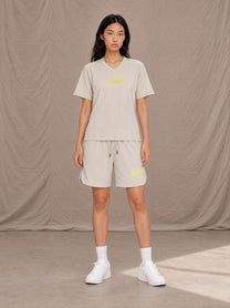 Model wearing SM Motion T-shirt in Oat Grey with SM Motion Oversized Court Shorts in Oat Grey, front view.