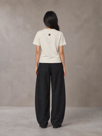 Model wearing SM Sig. Henley T-shirt in Oat Grey, rear view.