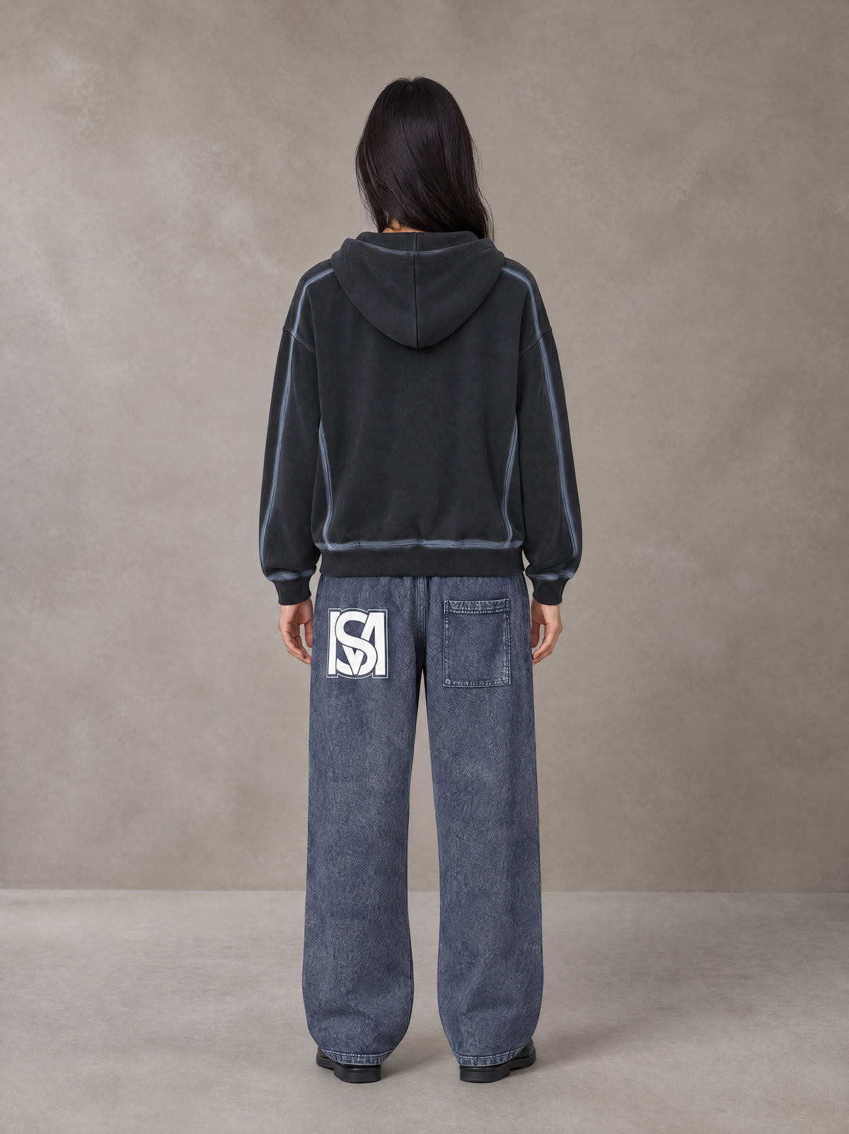 Model wearing SM Acid Wash Trousers in Deep Denim, rear view.