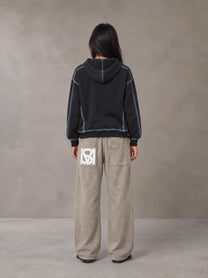Model wearing SM Acid Wash Trousers in Stone Grey, rear view.