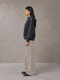 Model wearing SM Acid Wash Trousers in Stone Grey, side view.