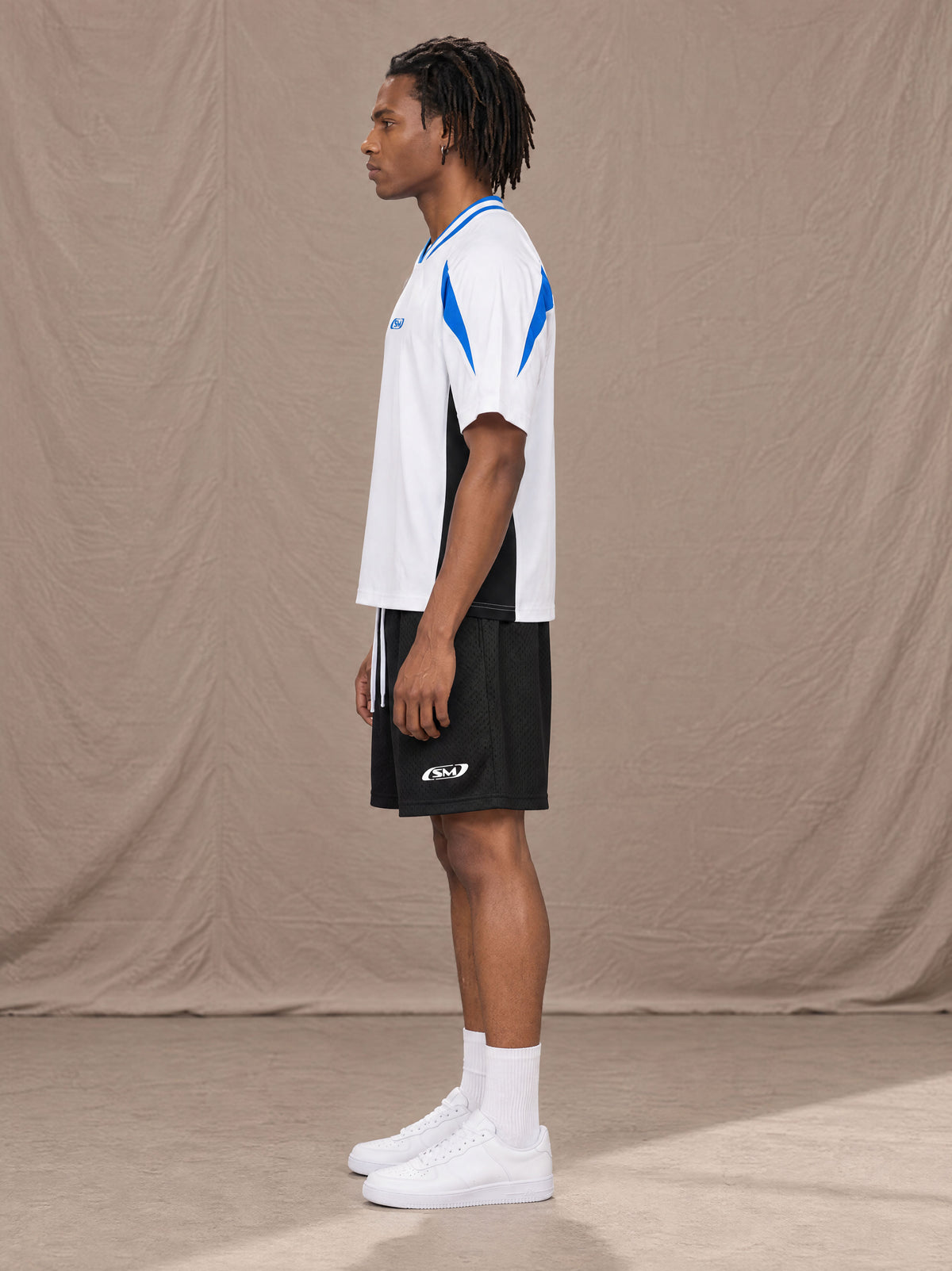 Model wearing SM Motion Vector Jersey in Lucent White, side view.