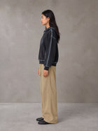 Model wearing SM Eternal Fleur Belted Trousers in Camel Tan, side view.
