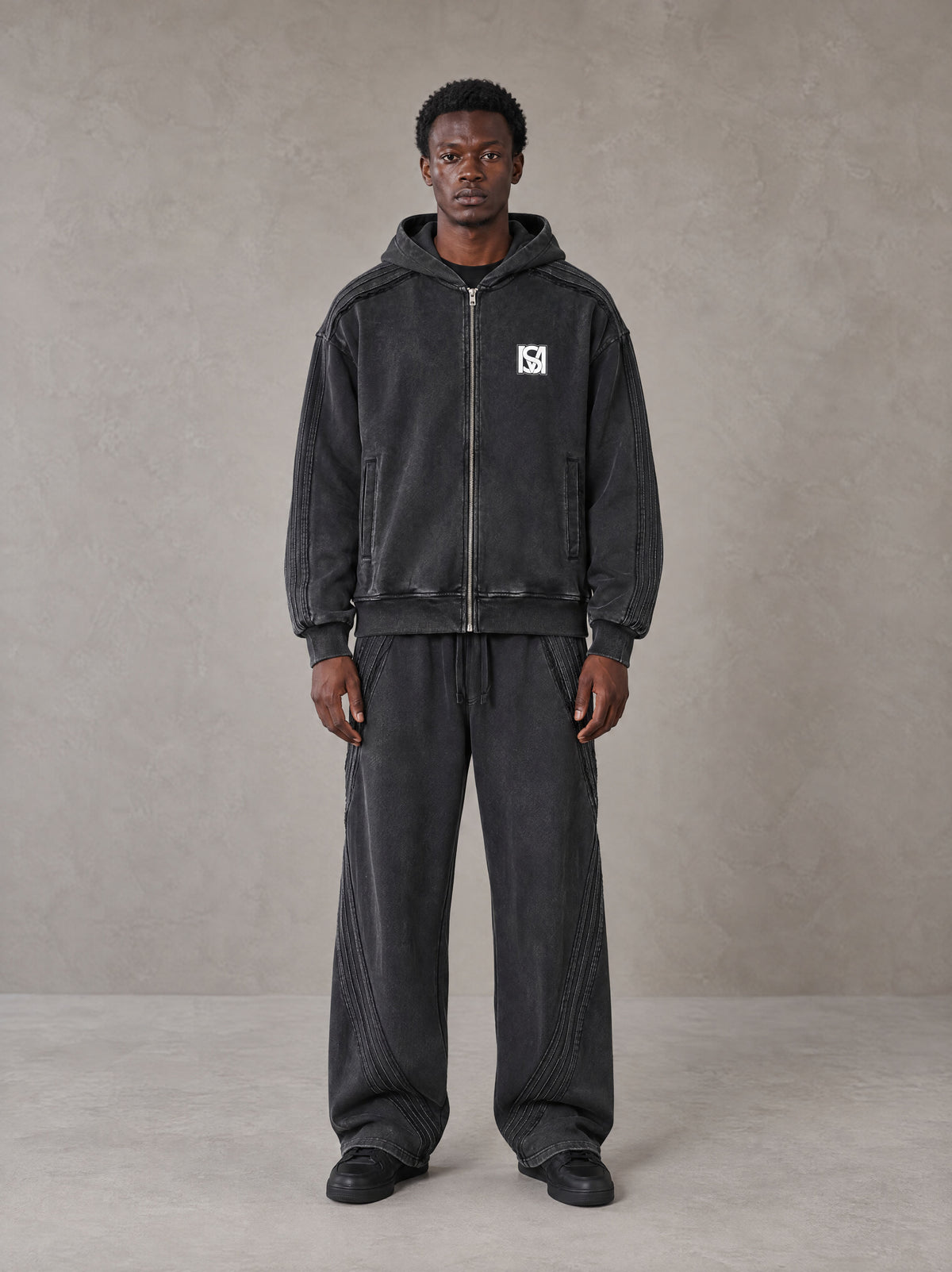 Model wearing the SM Arc Hoodie and SM Arc Sweatpants in Midnight Black, front view.