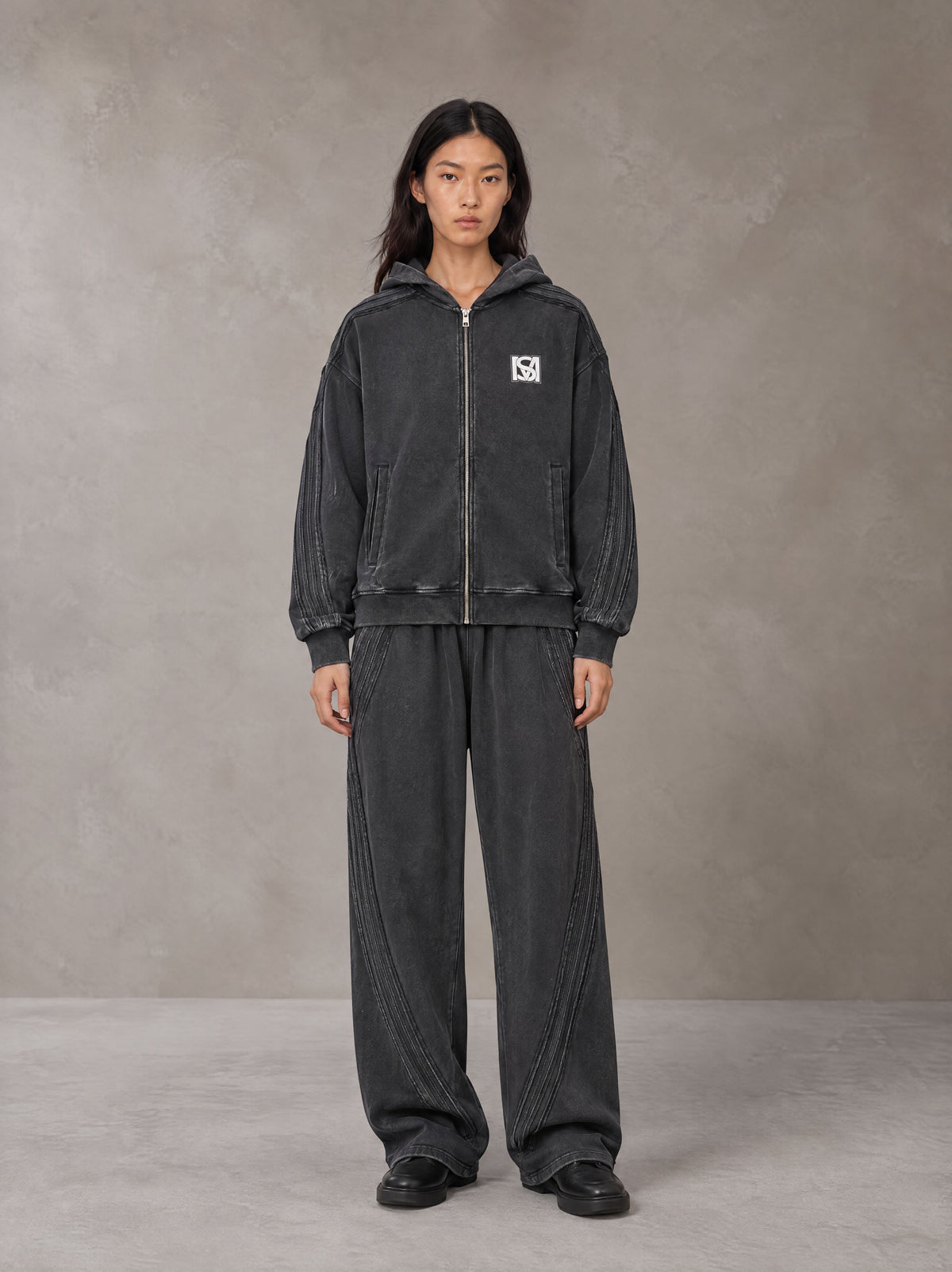Model wearing the SM Arc Hoodie and SM Arc Sweatpants in Midnight Black, front view.