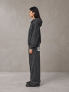 Model wearing the SM Arc Hoodie and SM Arc Sweatpants in Midnight Black, side profile.