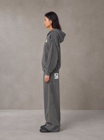 Model wearing the SM Arc Hoodie and SM Arc Sweatpants in Deep Charcoal, side profile.