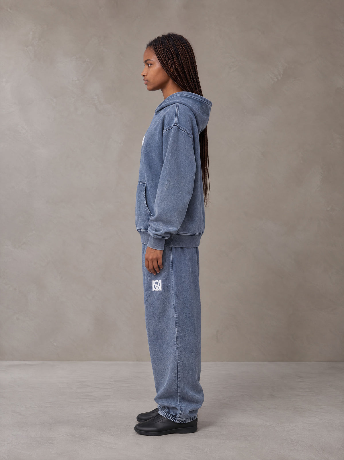 Model wearing the SM Denim Wash Hoodie and SM Denim Wash Sweatpants in Chambray, side profile.