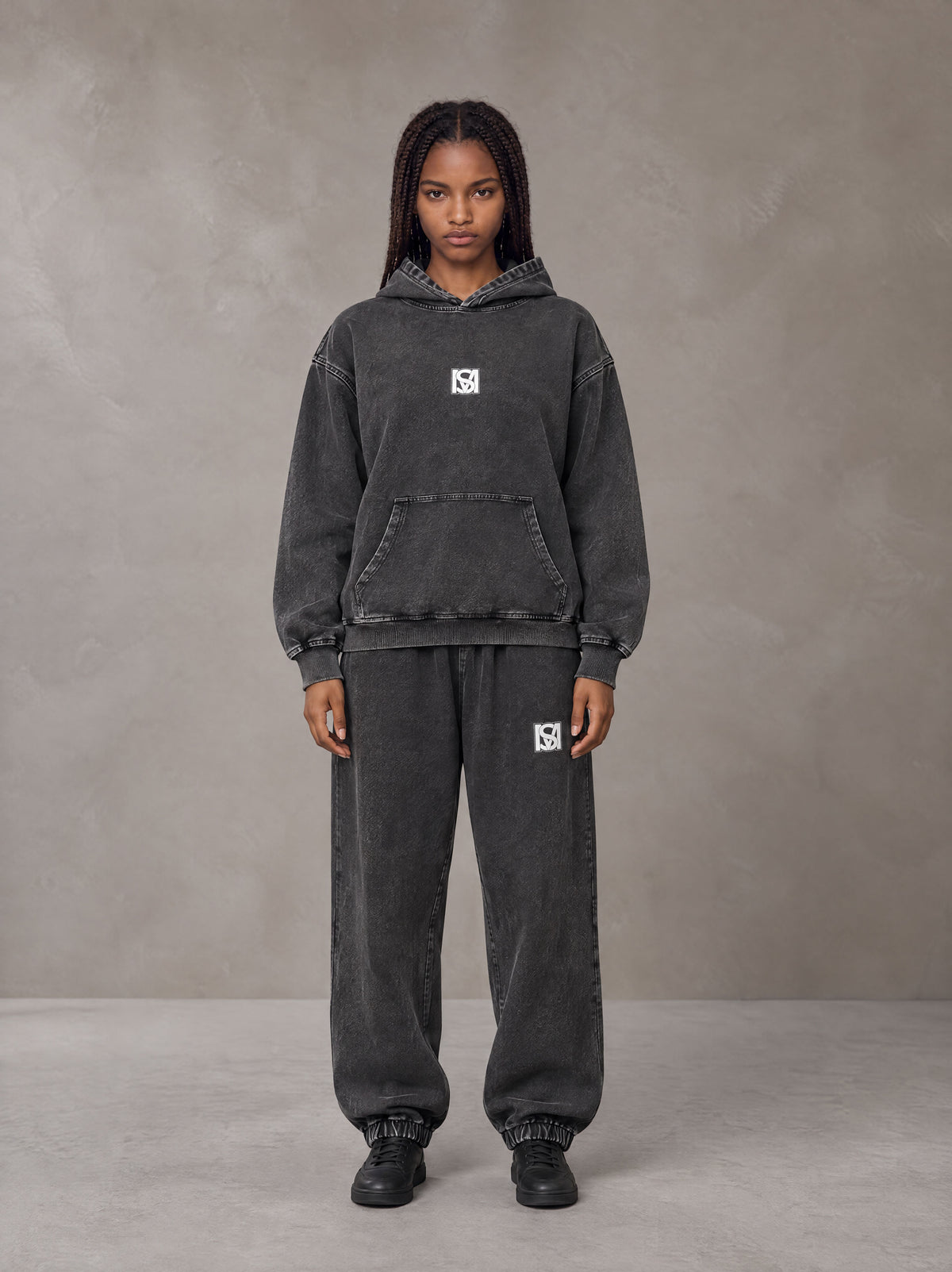 Model wearing the SM Denim Wash Hoodie and SM Denim Wash Sweatpants in Midnight Black, front view.