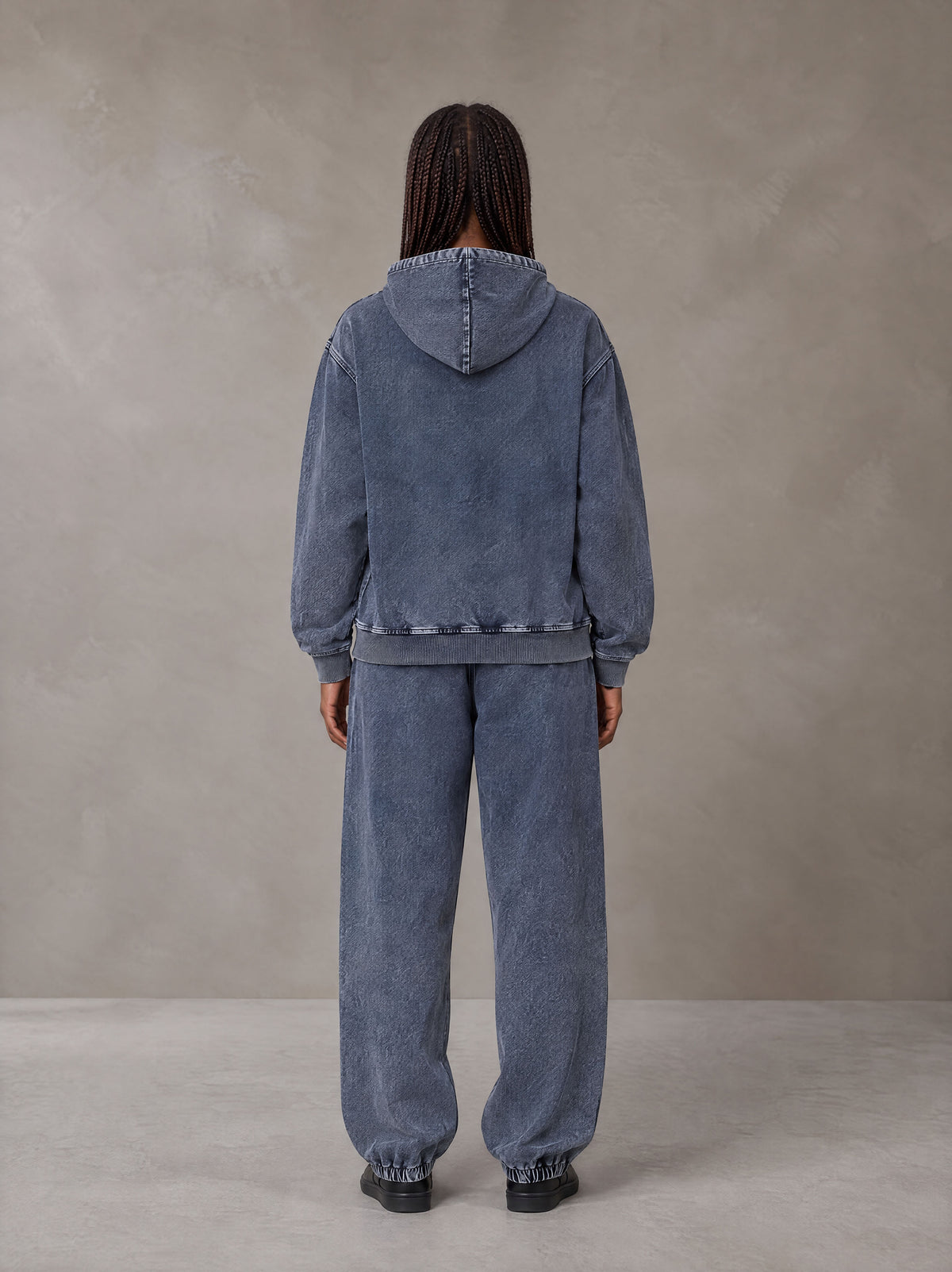 Model wearing the SM Denim Wash Hoodie and SM Denim Wash Sweatpants in Oxford Navy, rear view.