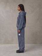 Model wearing the SM Denim Wash Hoodie and SM Denim Wash Sweatpants in Oxford Navy, side profile.