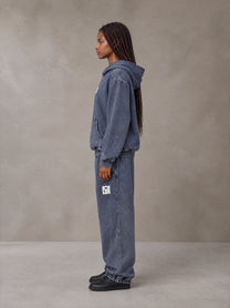Model wearing the SM Denim Wash Hoodie and SM Denim Wash Sweatpants in Oxford Navy, side profile.