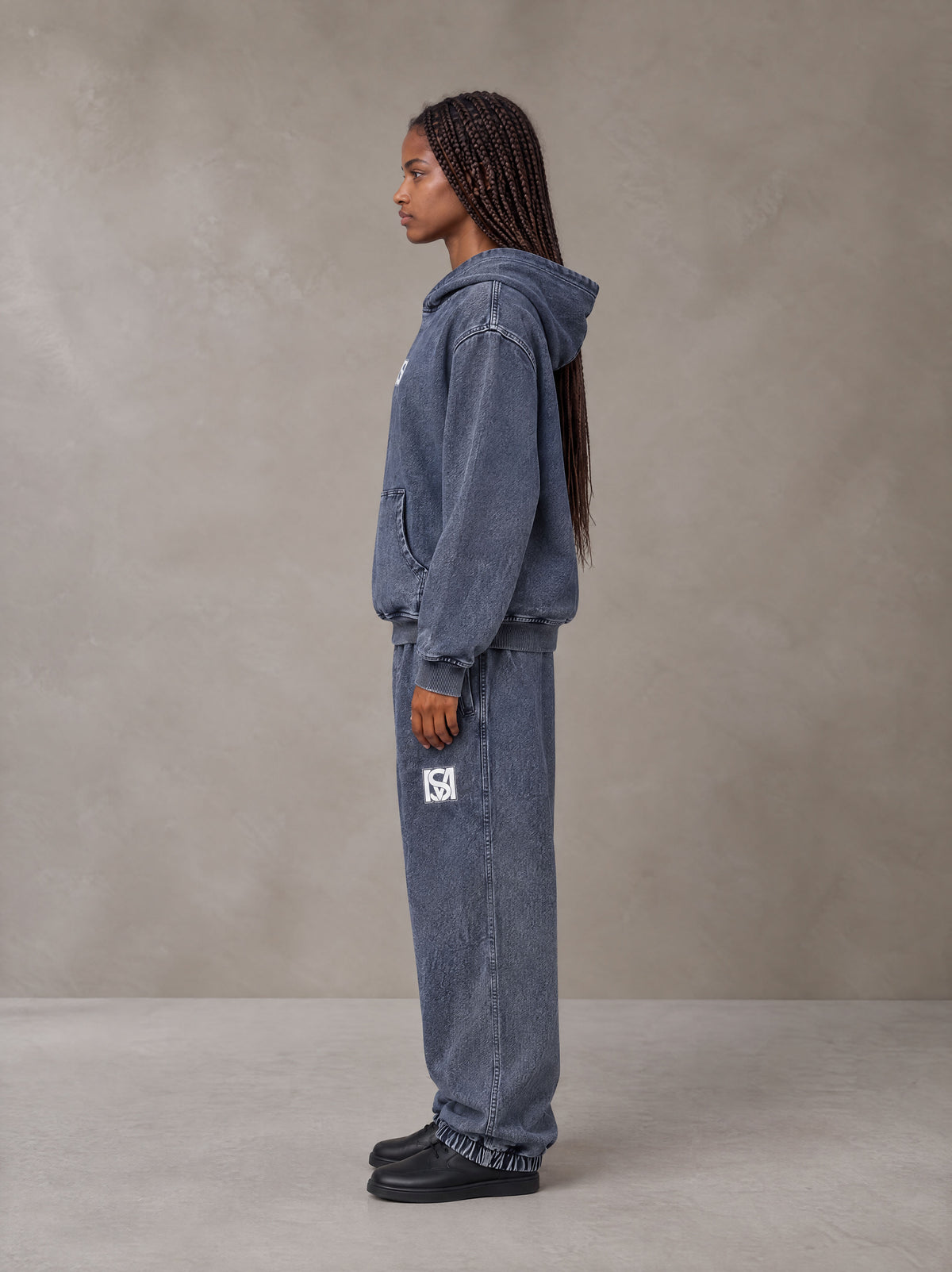 Model wearing the SM Denim Wash Hoodie and SM Denim Wash Sweatpants in Oxford Navy, side profile.