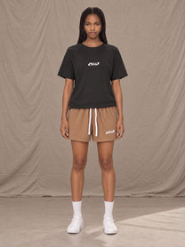 Model wearing the SM Motion Mesh Shorts in French Beige, front view.