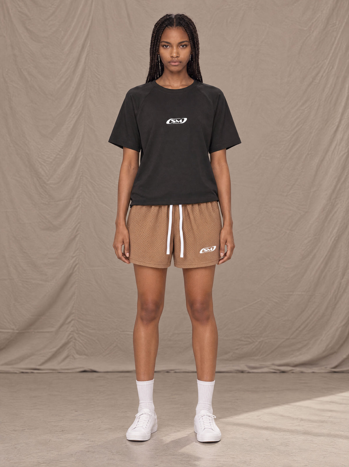 Model wearing the SM Motion Mesh Shorts in French Beige, front view.