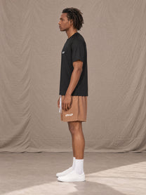 Model wearing the SM Motion Mesh Shorts in French Beige, side profile.