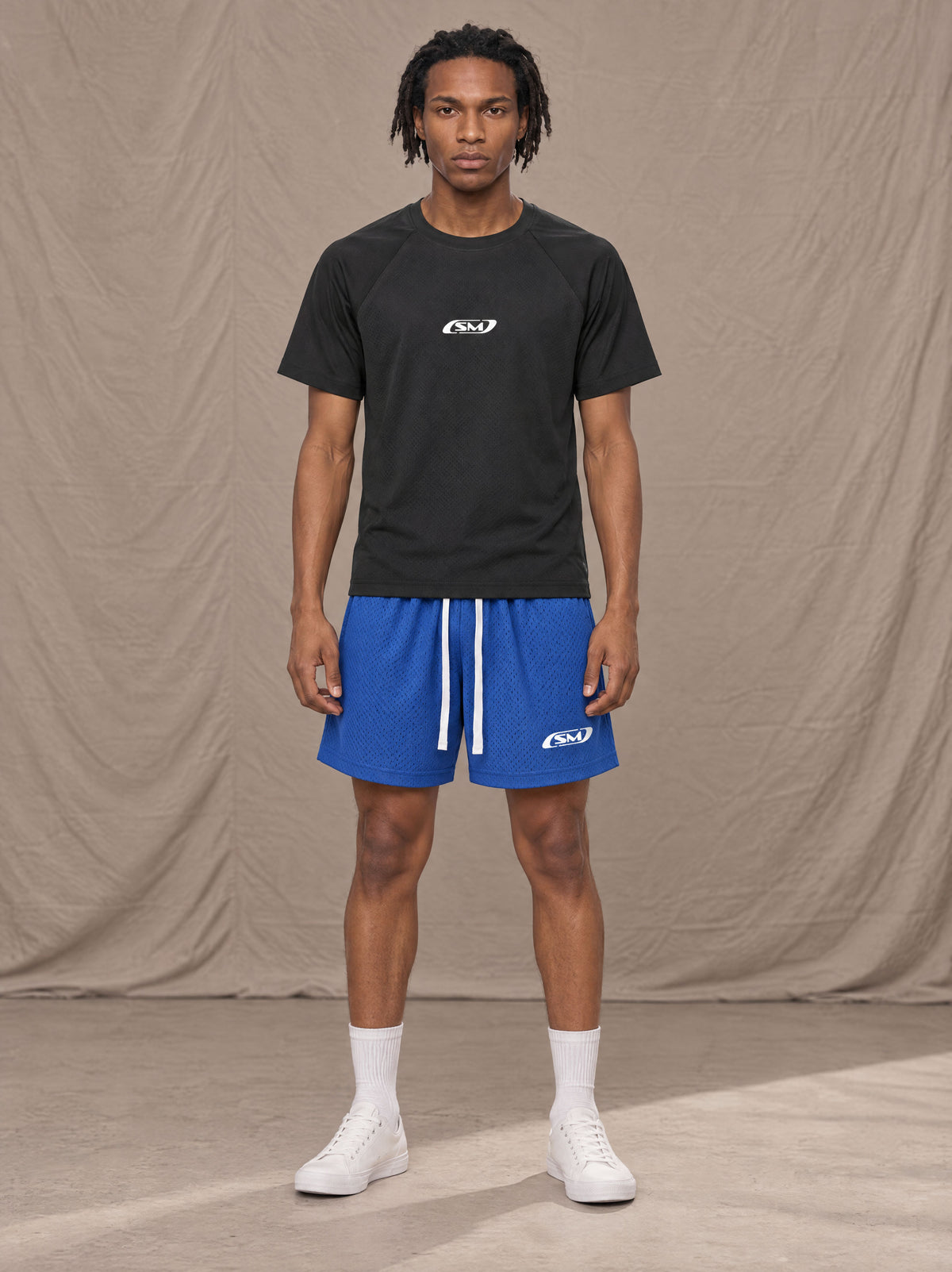 Model wearing the SM Motion Mesh Shorts in Klein Blue, front view.