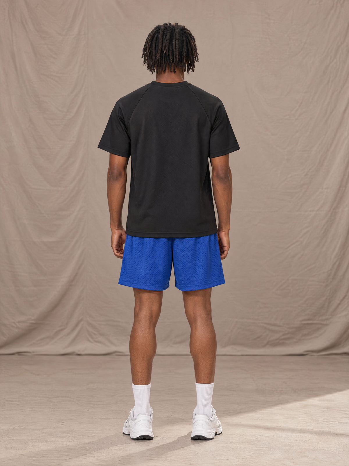 Model wearing the SM Motion Mesh Shorts in Klein Blue, rear view.