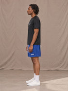 Model wearing the SM Motion Mesh Shorts in Klein Blue, side profile.