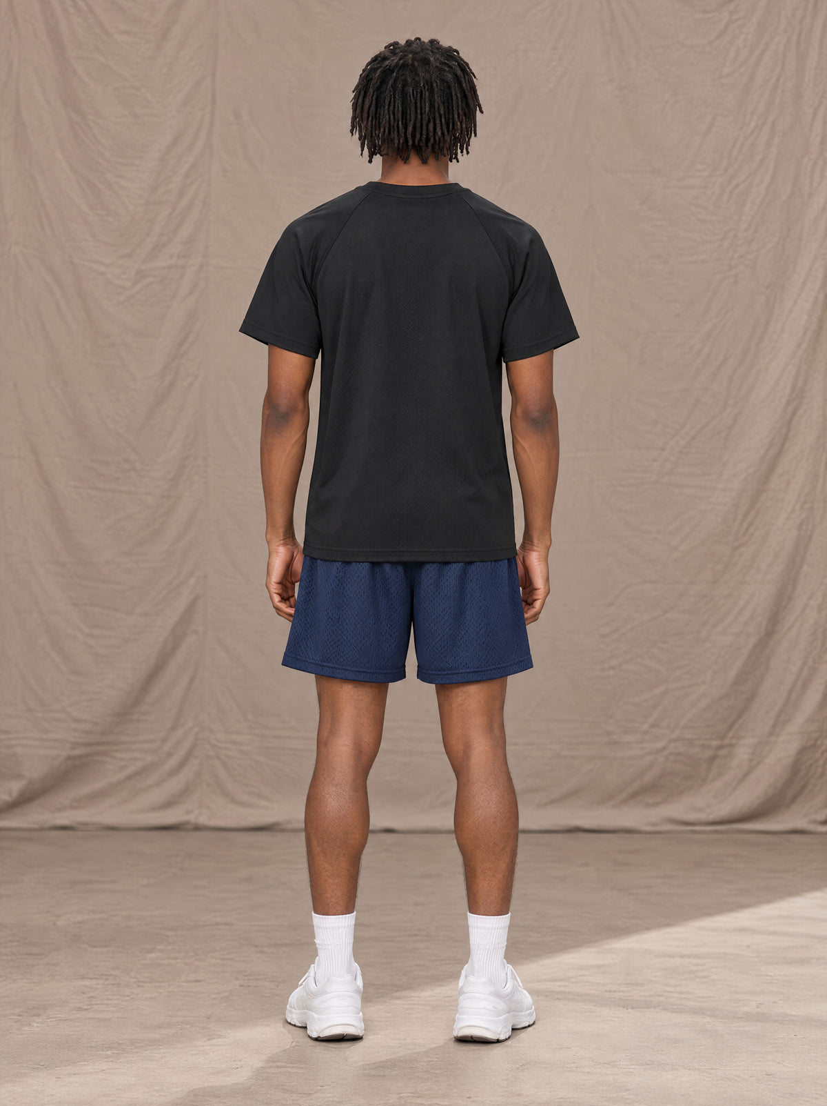 Model wearing the SM Motion Mesh Shorts in Oxford Navy, rear view.