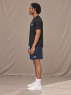 Model wearing the SM Motion Mesh Shorts in Oxford Navy, side profile.