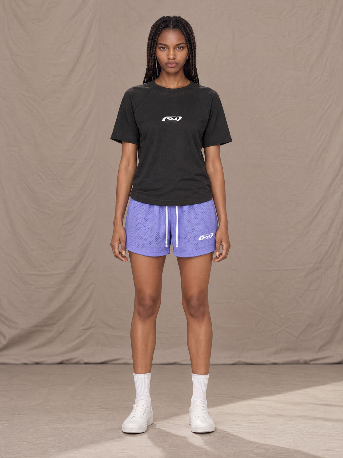 Model wearing the SM Motion Mesh Shorts in Pastel Violet, front view.