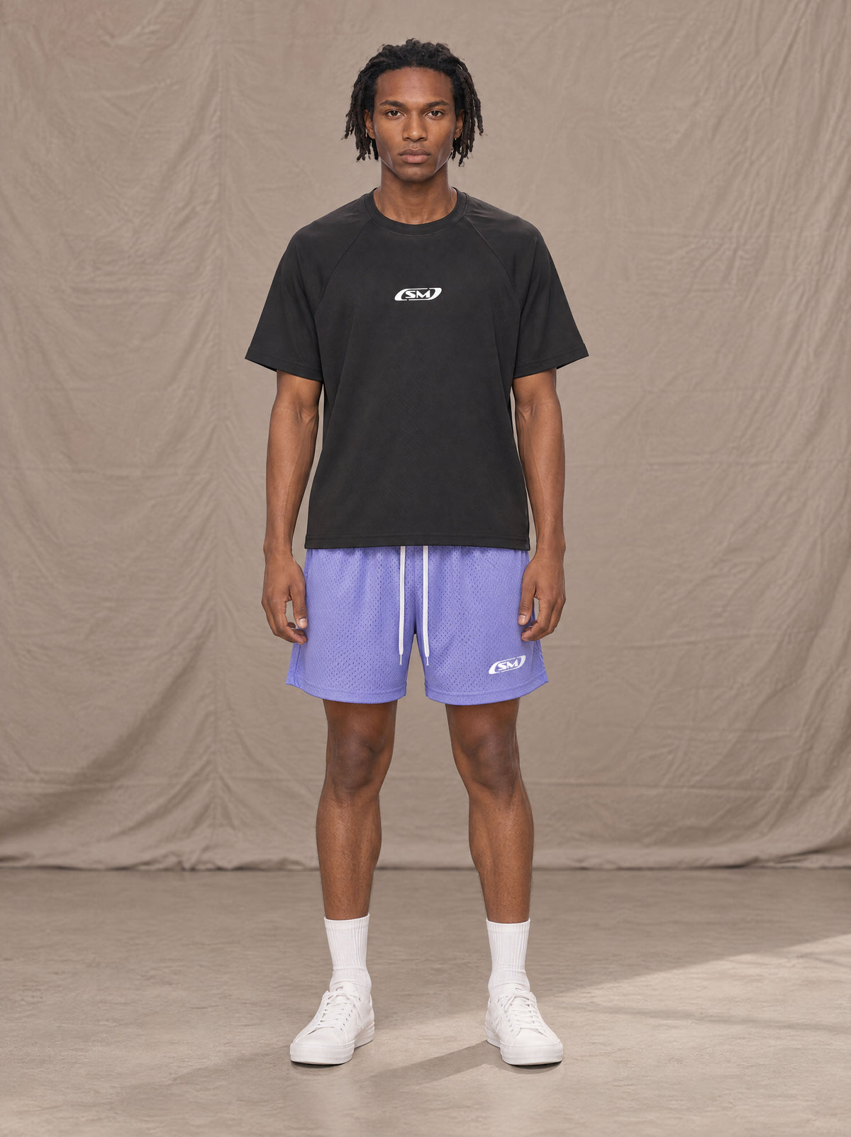 Model wearing the SM Motion Mesh Shorts in Pastel Violet, front view.