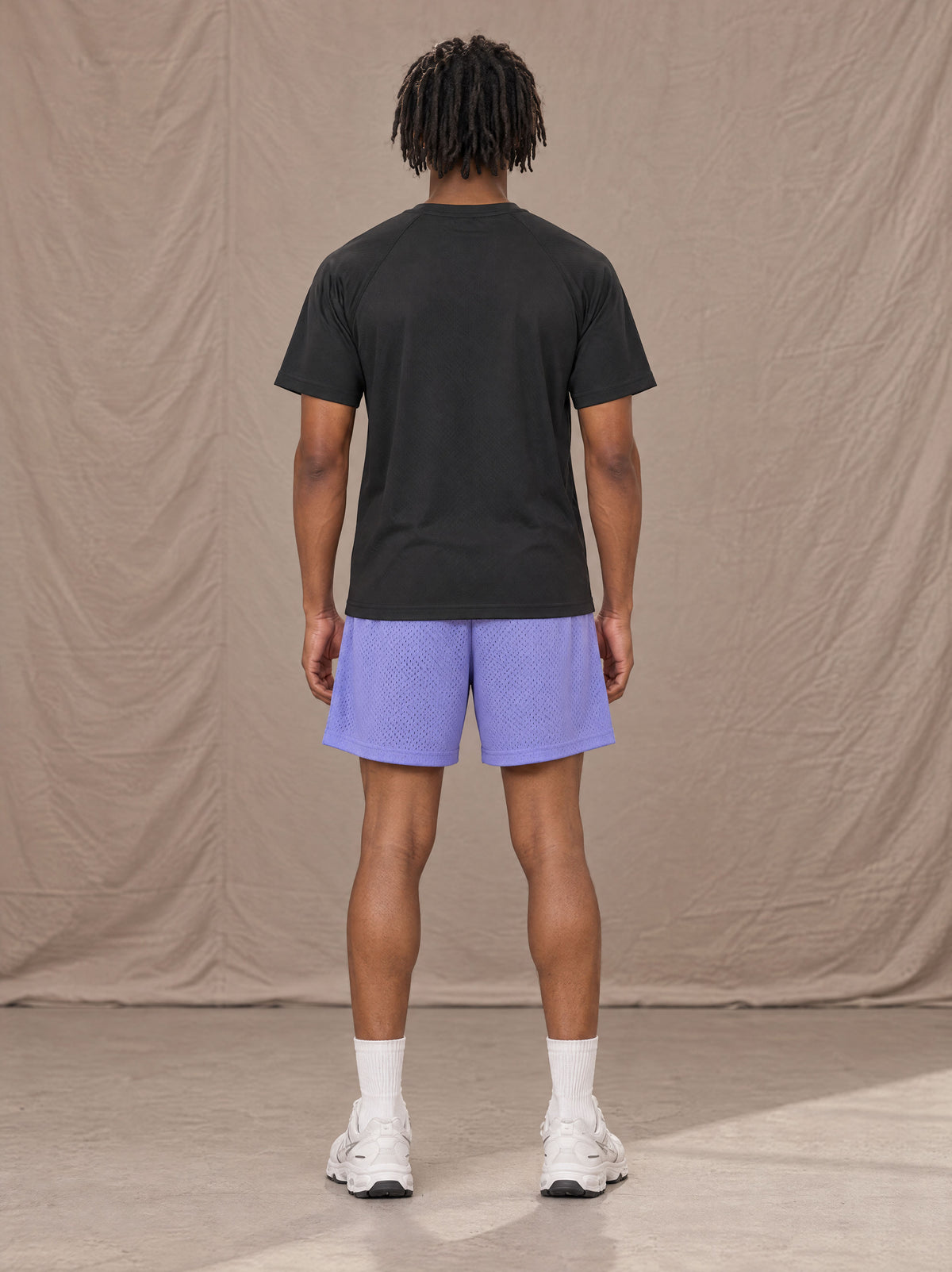 Model wearing the SM Motion Mesh Shorts in Pastel Violet, rear view.