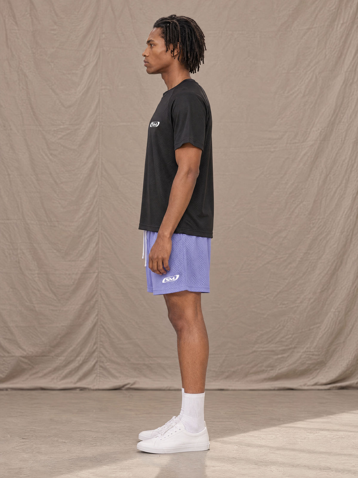 Model wearing the SM Motion Mesh Shorts in Pastel Violet, side profile.