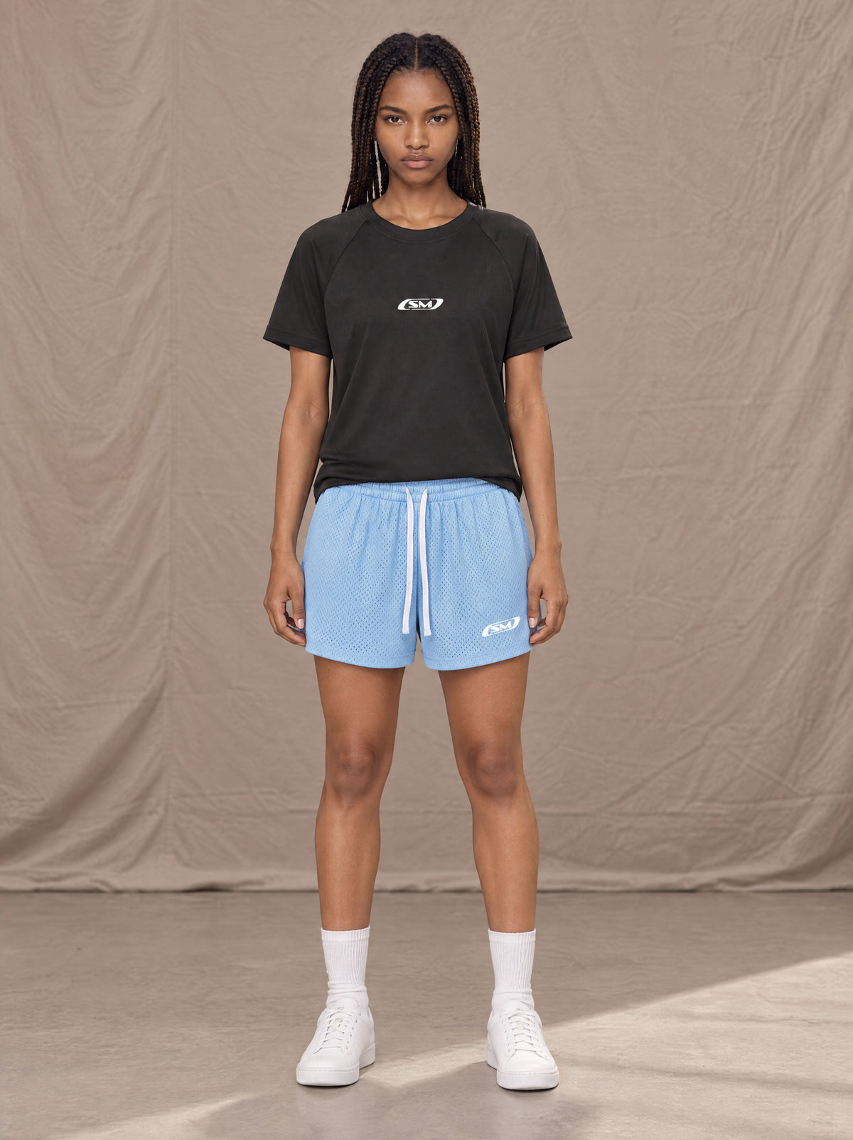 Model wearing the SM Motion Mesh Shorts in Sky Tint, front view.