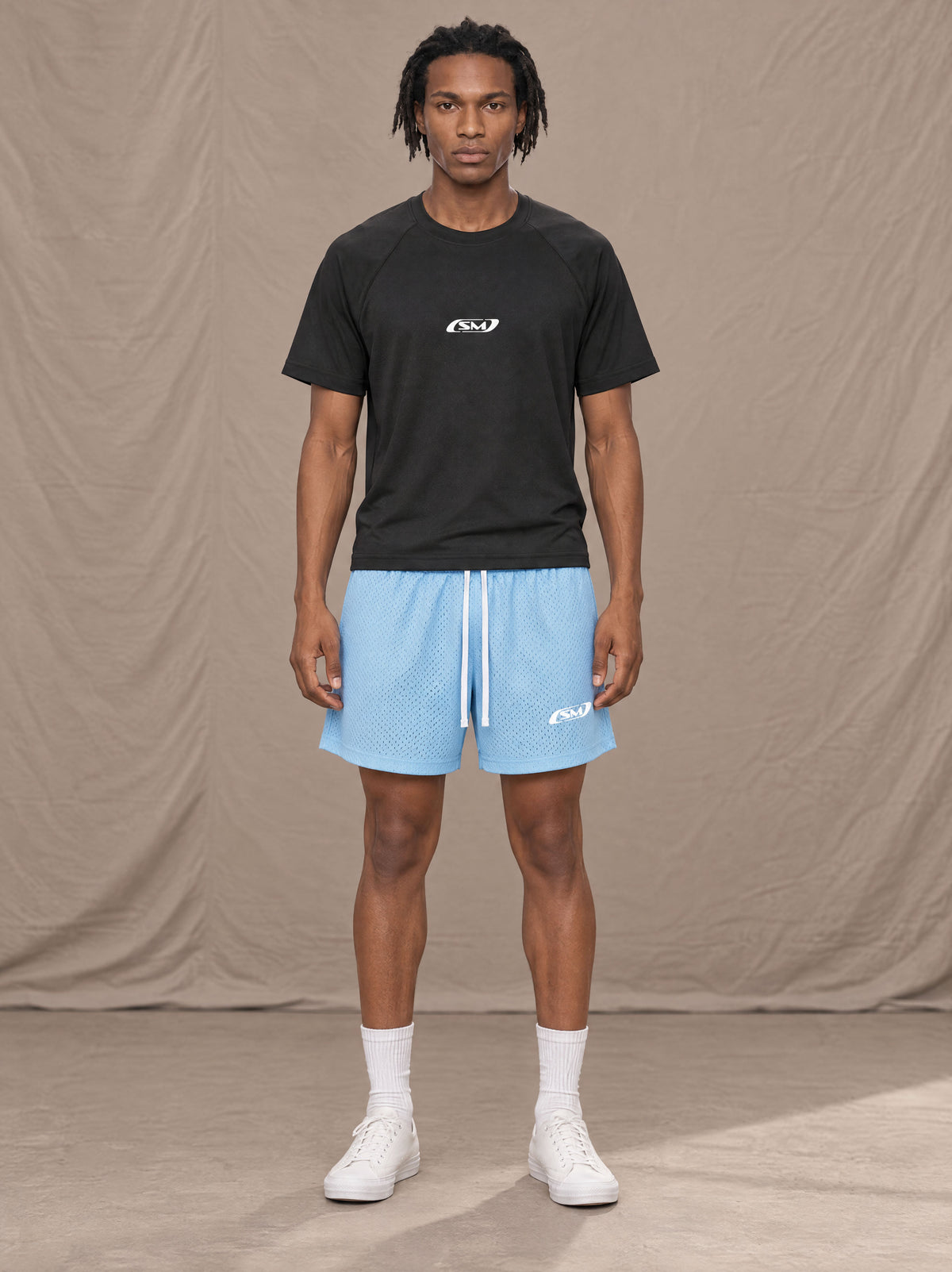 Model wearing the SM Motion Mesh Shorts in Sky Tint, front view.