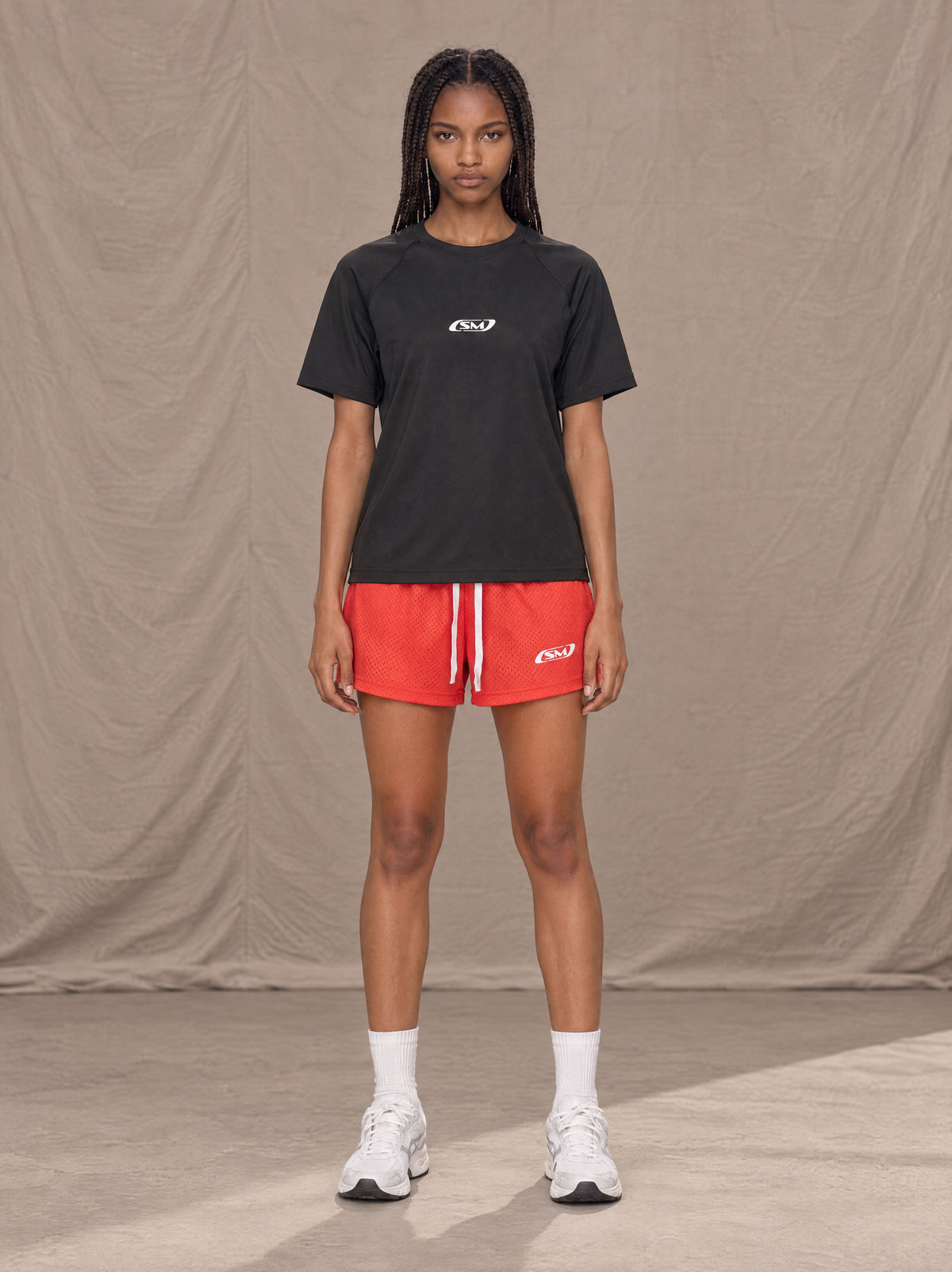 Model wearing the SM Motion Mesh Shorts in Watermelon Tint, front view.