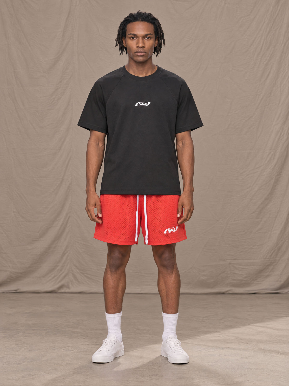 Model wearing the SM Motion Mesh Shorts in Watermelon Tint, front view.