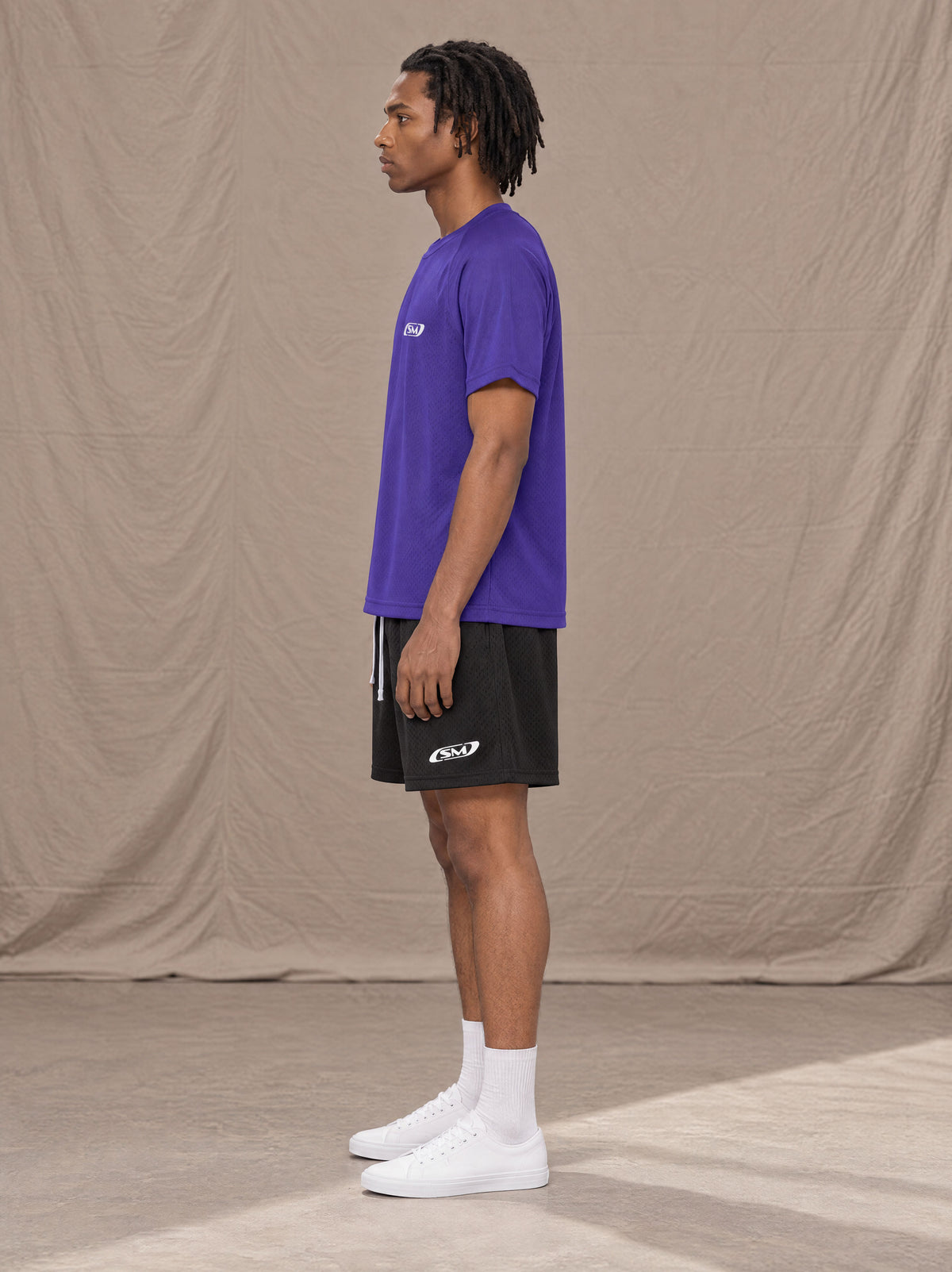Model wearing the SM Motion Mesh T-shirt in Rich Violet, side profile.