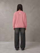Model wearing the SM Sig. Washed Distress Knit Sweater in Blush Rose, rear view.