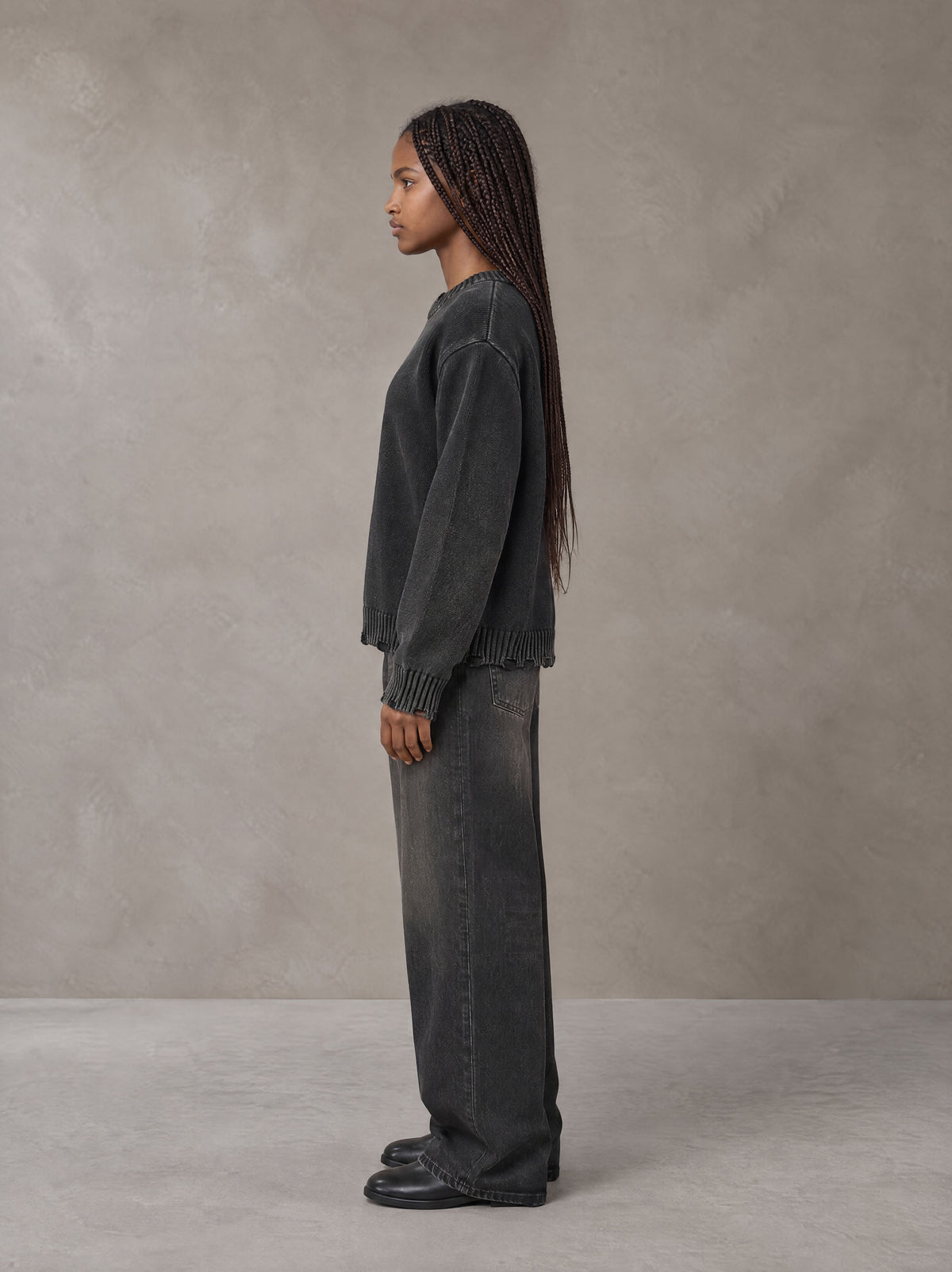 Model wearing the SM Sig. Washed Distress Knit Sweater in Midnight Black, side profile.