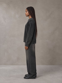 Model wearing the SM Sig. Washed Distress Knit Sweater in Midnight Black, side profile.